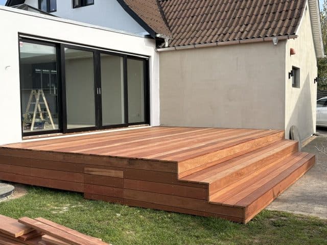 Terrasse med hårdttræsdæk og store glaspartier ind til boligen